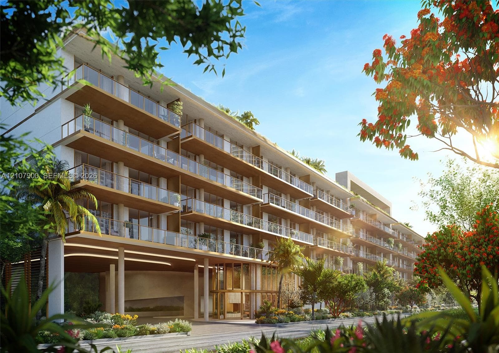 Multi-story modern building featuring expansive private balconies, glass railings, wood-toned soffits, and a covered ground-level porte-cochère with integrated landscape planting