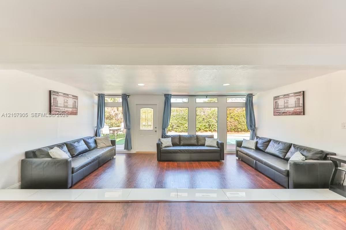 Sunken living area featuring wood-finish flooring, recessed lighting, and multiple paneled glass windows