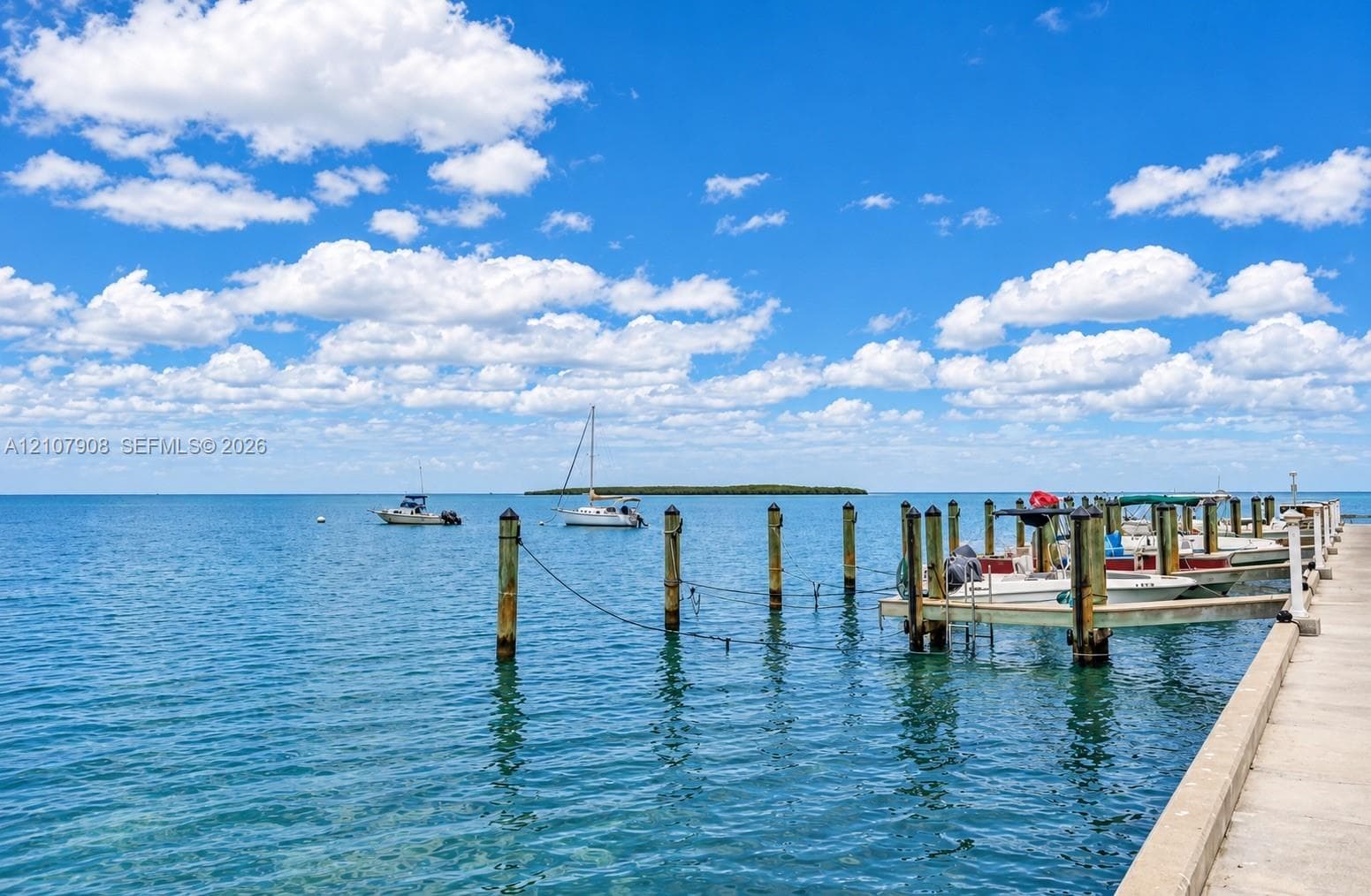Concrete dock featuring a series of wooden pilings and direct deep-water access