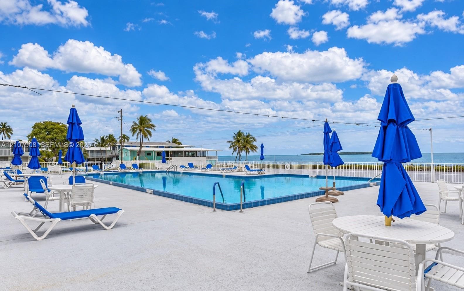 Outdoor swimming pool featuring a concrete deck and metal pool ladder