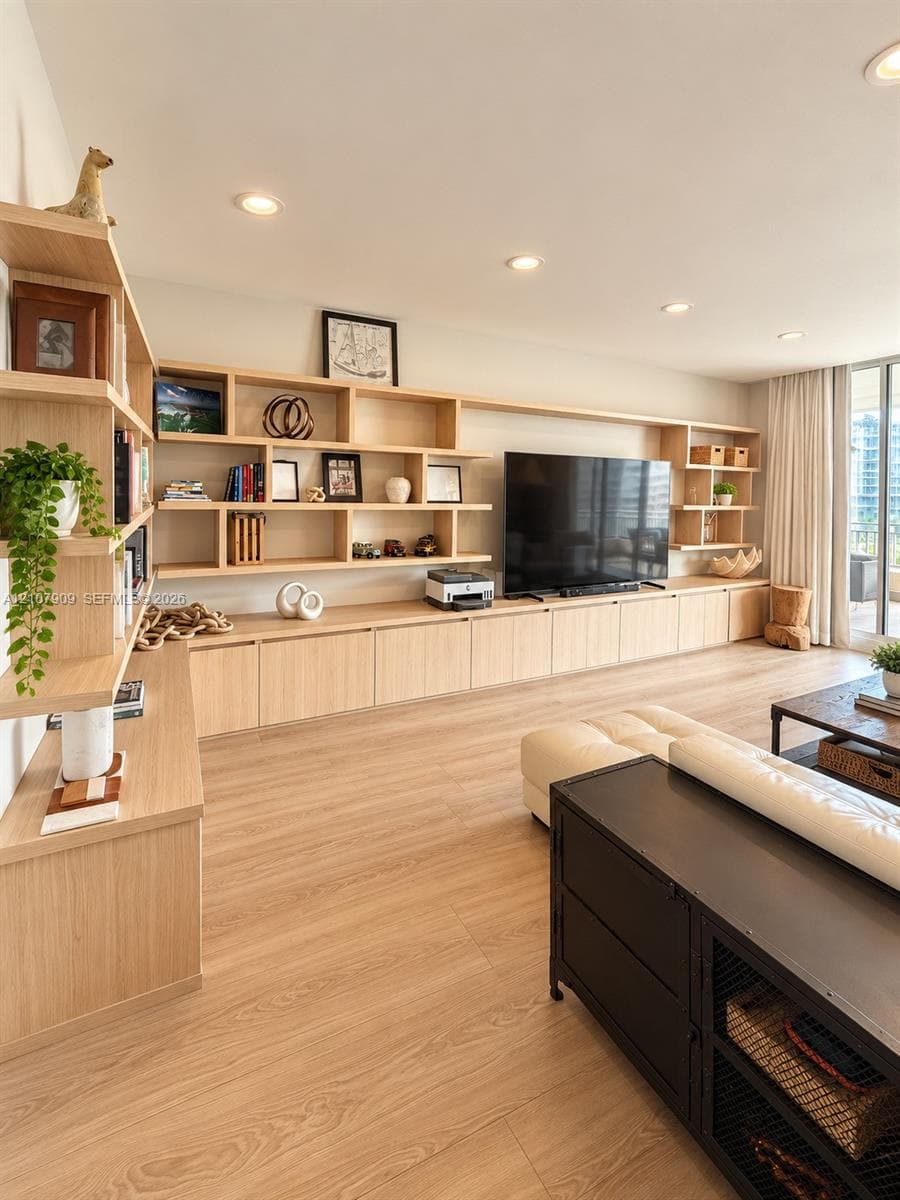 Custom floor-to-ceiling wood-finish cabinetry, extensive open shelving, recessed lighting, and wood-finish flooring