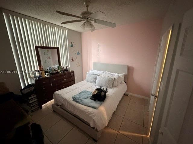 Bedroom featuring ceramic tile flooring, vertical window blinds, and a ceiling fan with integrated lighting
