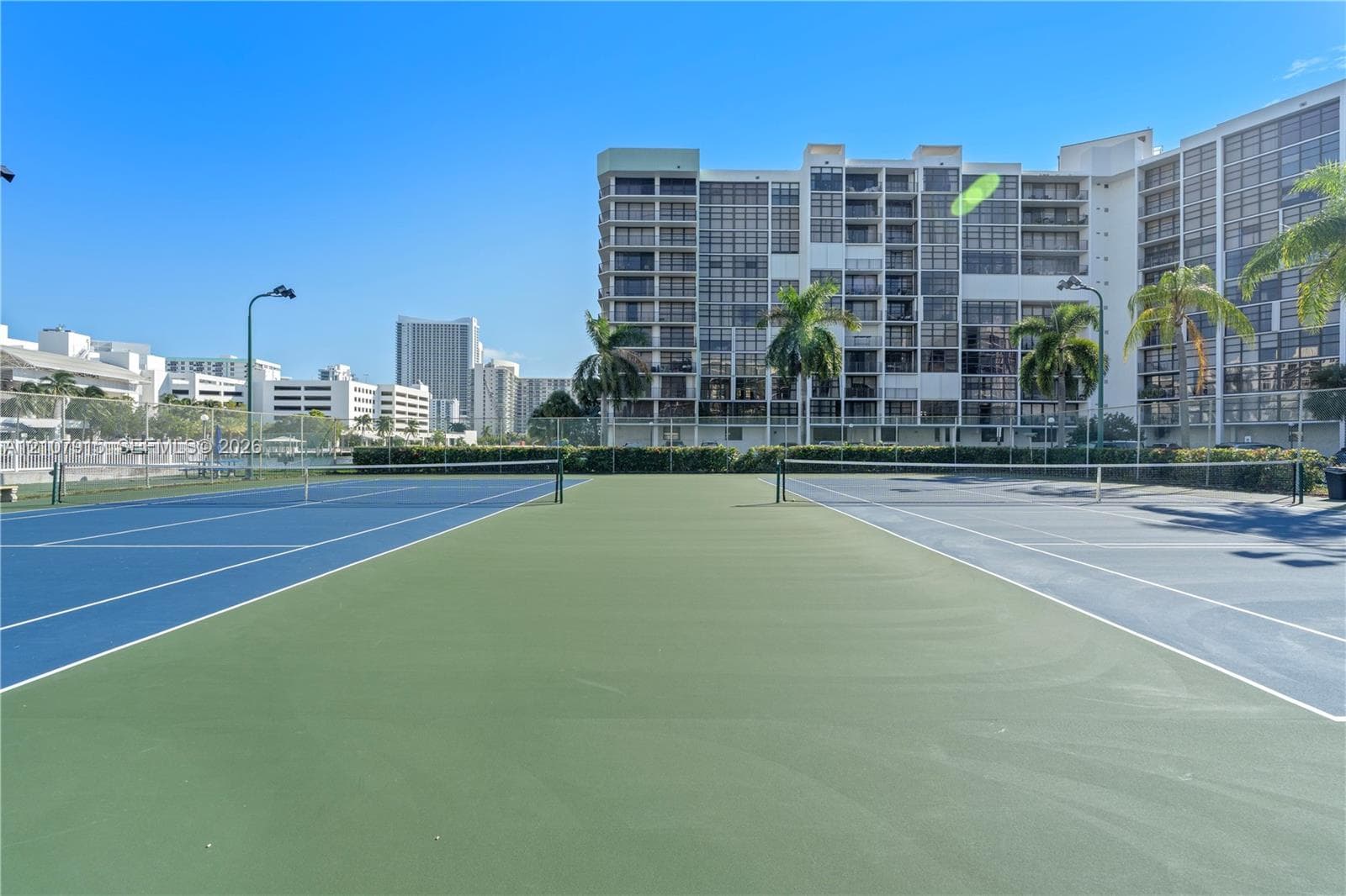 Multi-court tennis facility featuring high-tension perimeter fencing and integrated court lighting