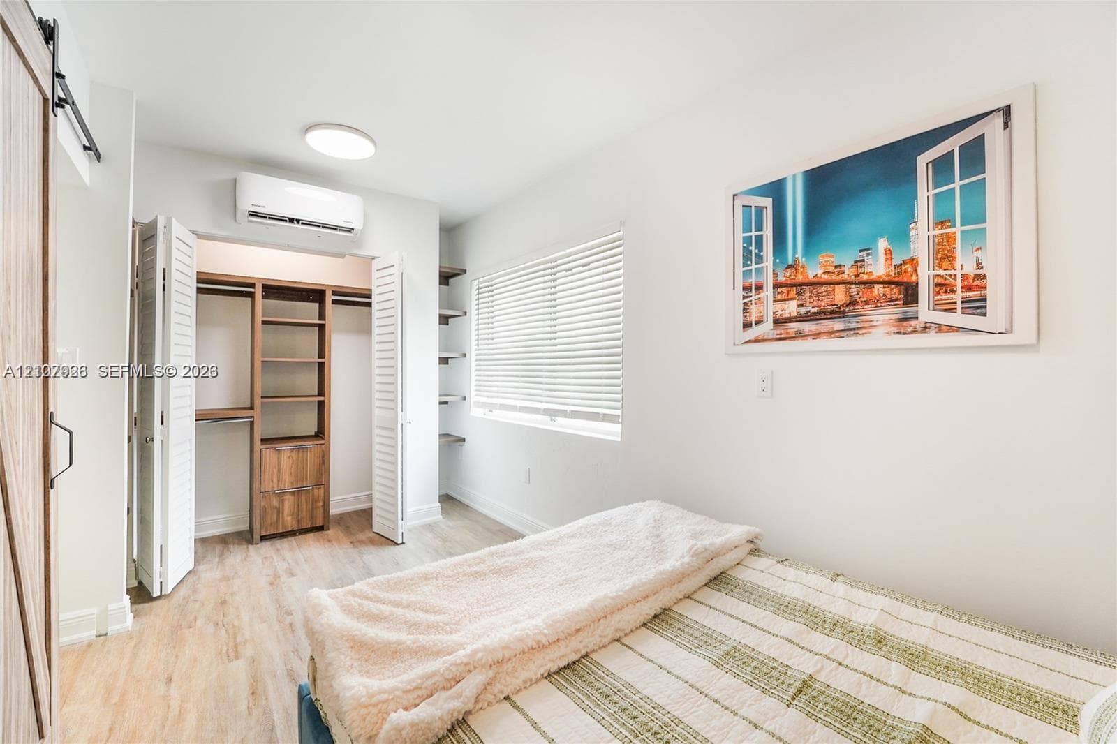 Custom closet system with integrated shelving and drawers, wood-finish flooring, wall-mounted climate control unit, and built-in corner shelving