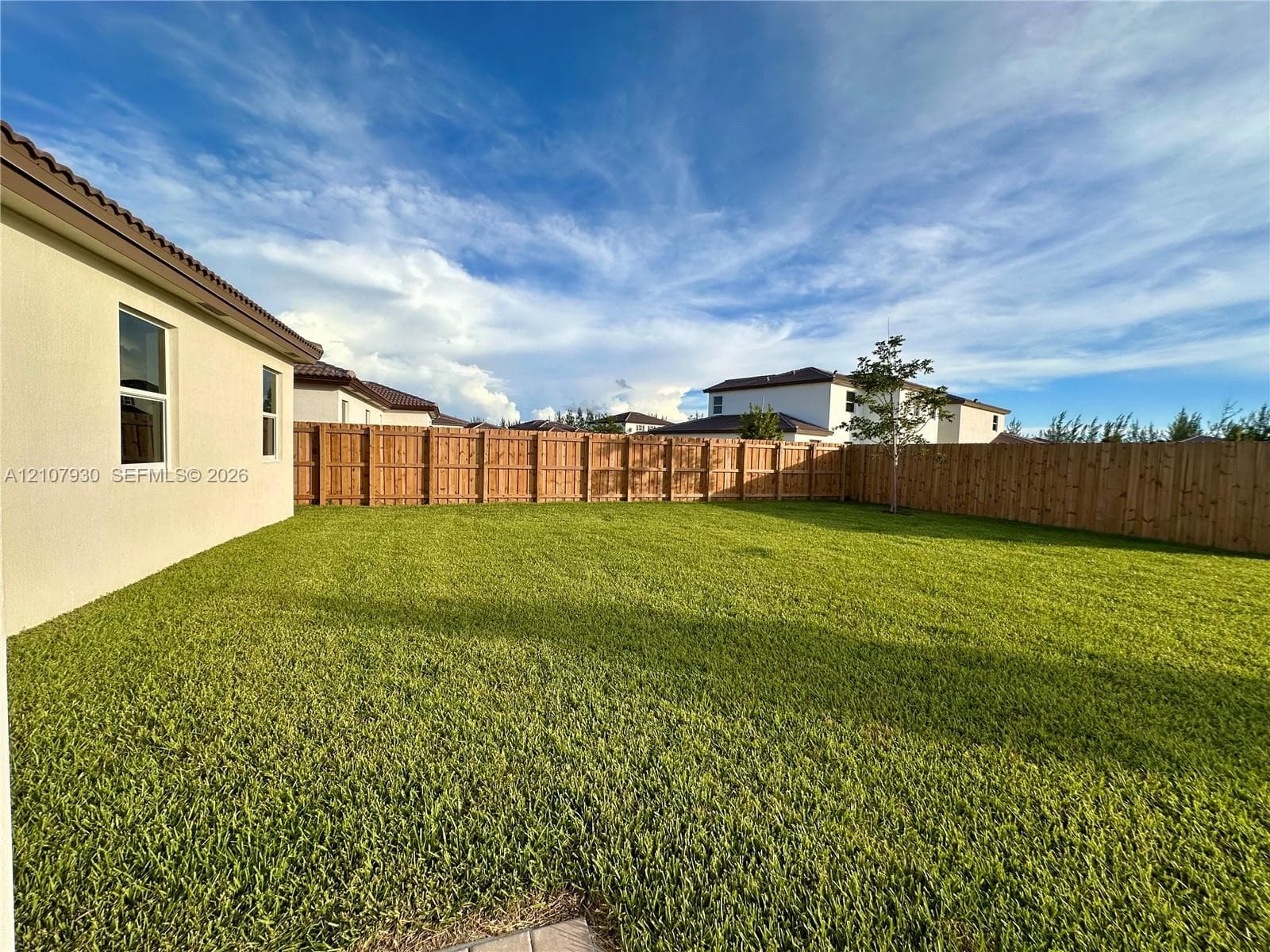 Expansive backyard featuring a level lawn and a wood privacy fence
