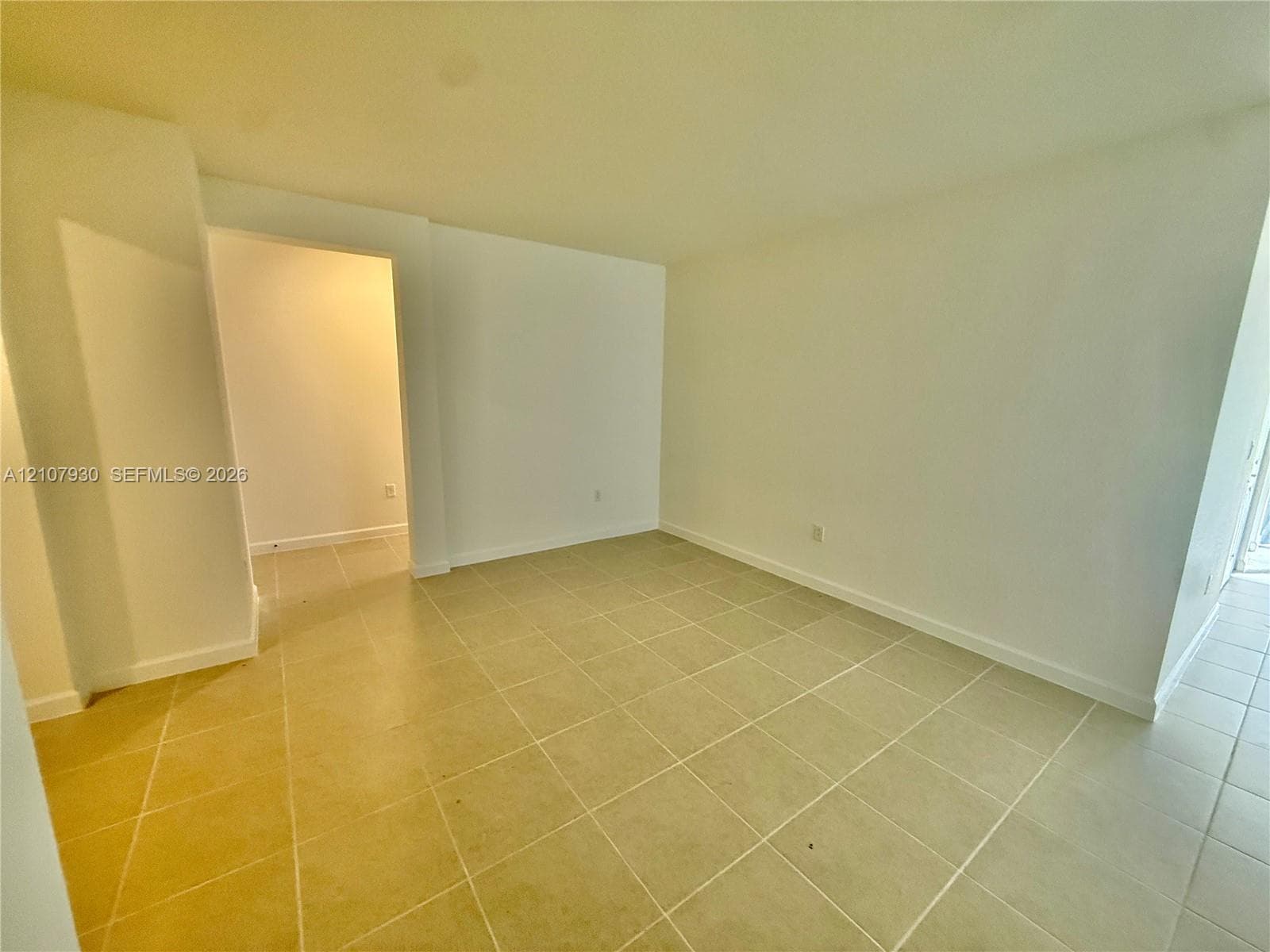 Interior space featuring neutral wall paint and light-colored square tile flooring
