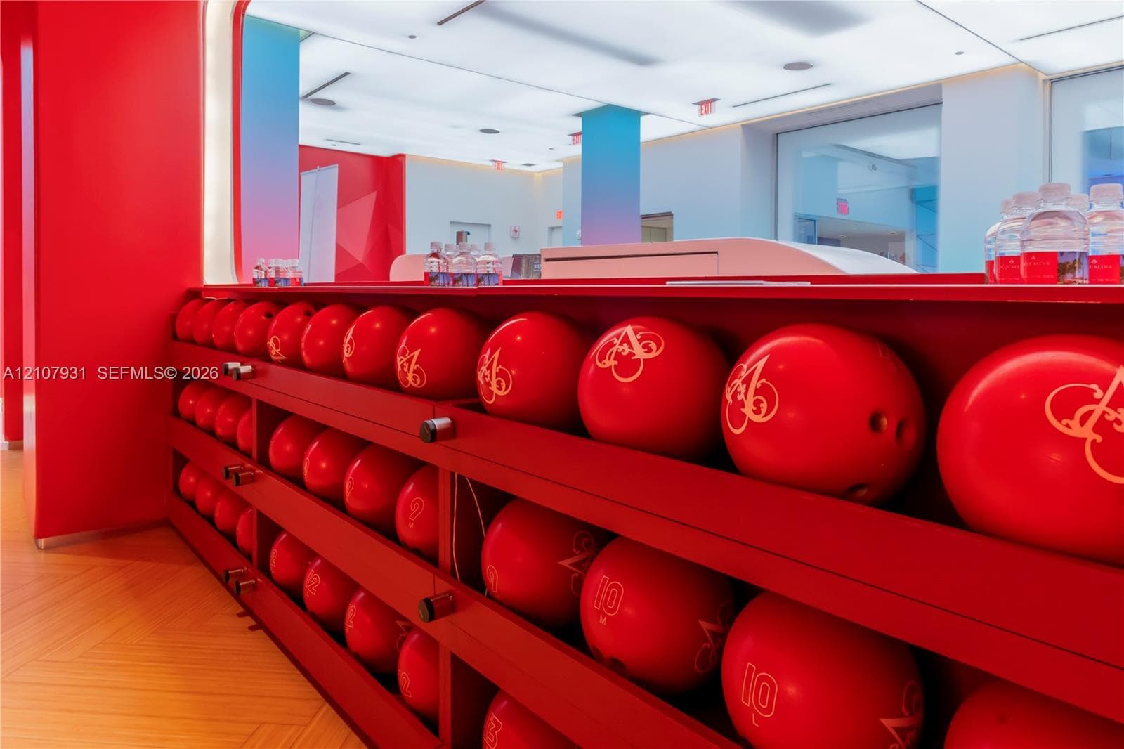 Built-in tiered red shelving unit featuring wood-finish flooring and integrated recessed ceiling lighting