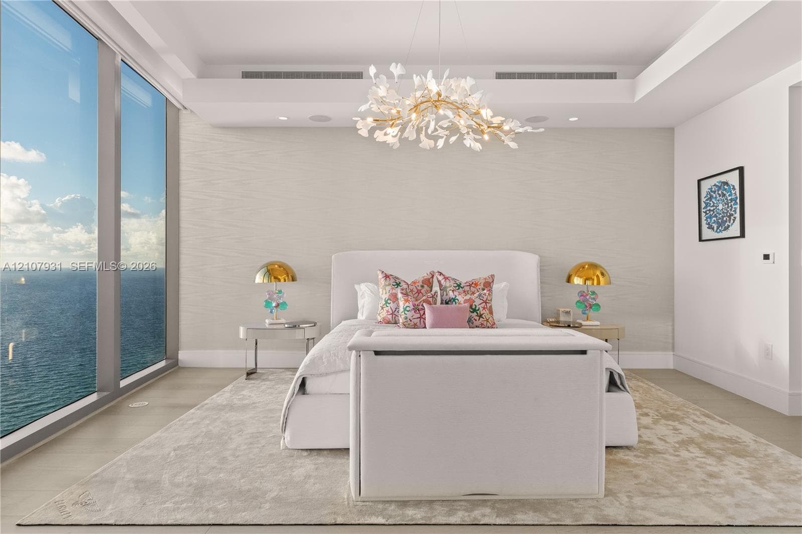 Floor-to-ceiling glass windows, custom tray ceiling, organic-inspired statement chandelier, and textured wall finish