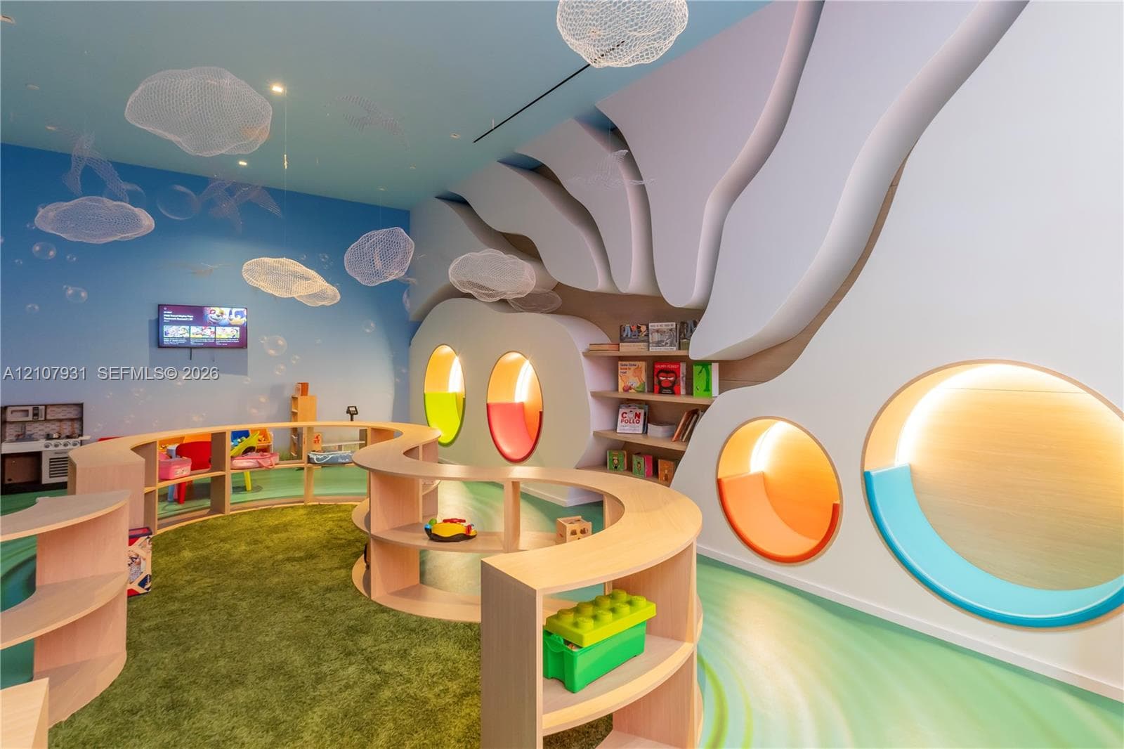 Custom interior featuring architectural wall treatments, built-in curved shelving units, recessed circular illuminated wall niches, and bespoke suspended light fixtures