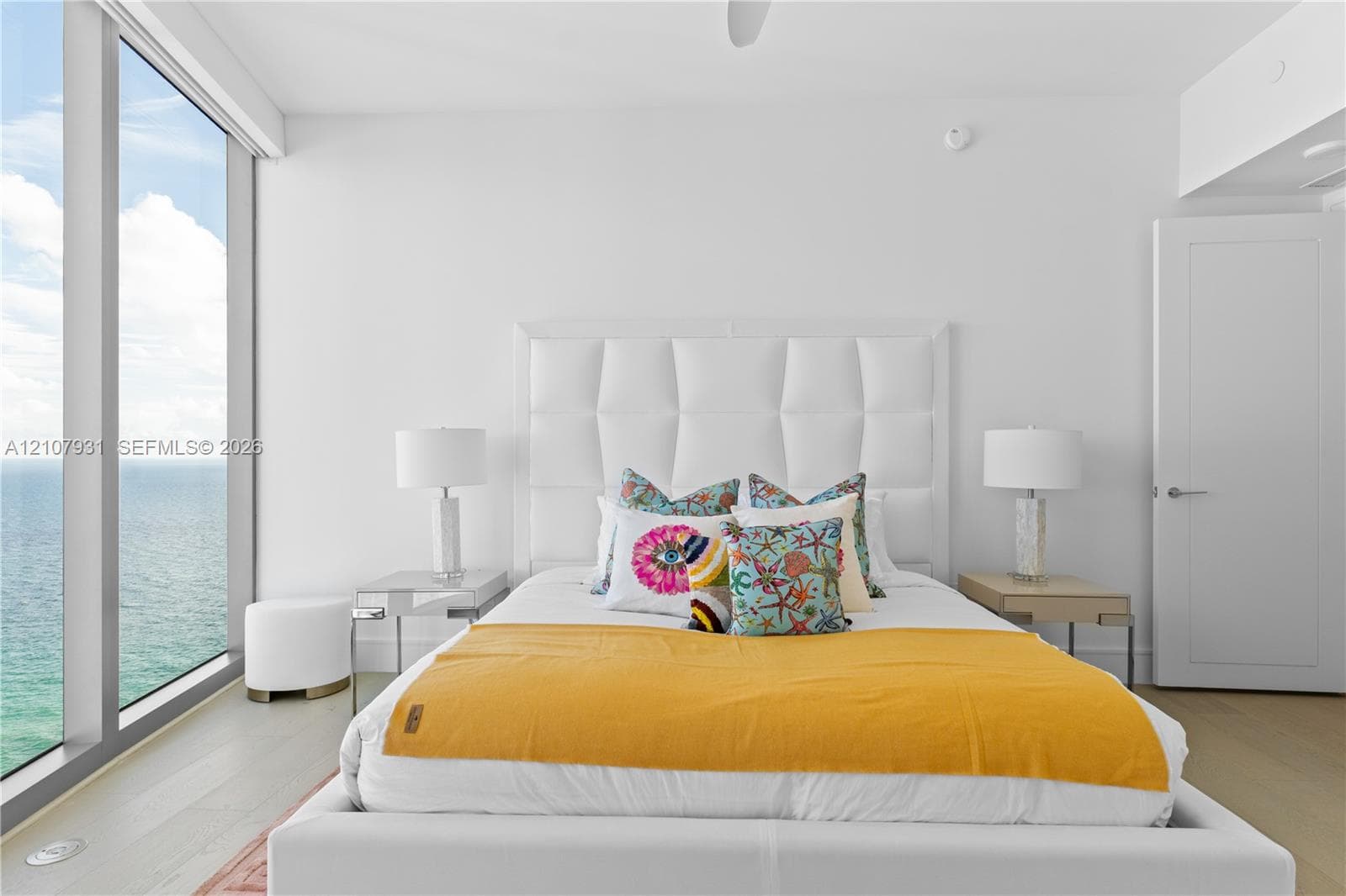 Floor-to-ceiling windows, wood-finish flooring, and white interior finishes