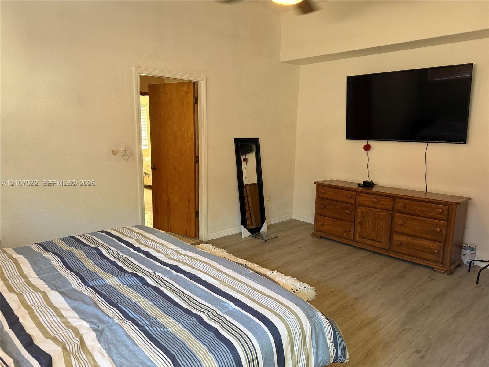 Wood-finish flooring and a ceiling-mounted light fixture with integrated fan