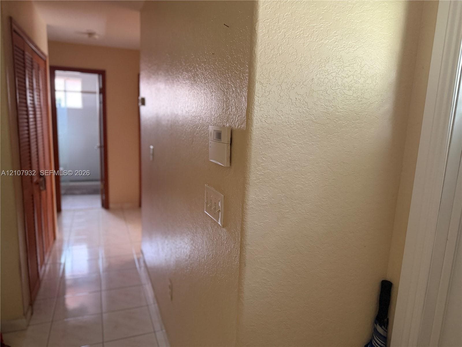 Ceramic tile flooring, louvered bi-fold closet doors, and wall-mounted climate control system