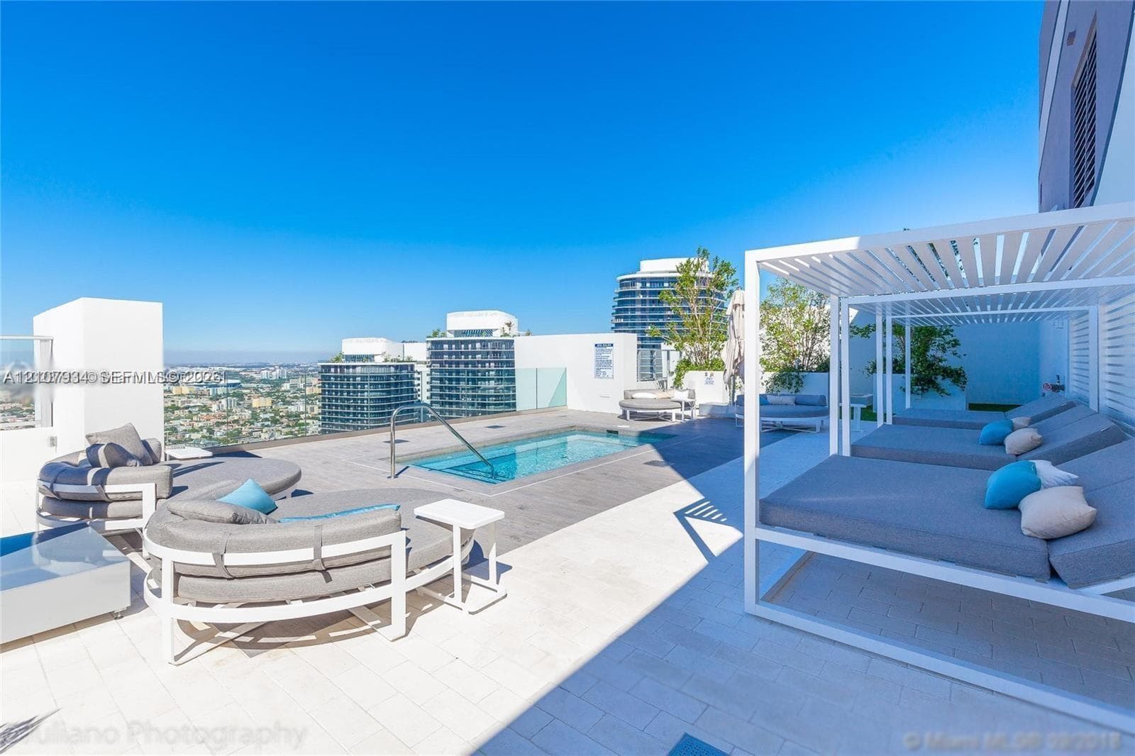 Rooftop terrace featuring an in-ground pool, glass panel perimeter railing, tile decking, and a built-in metal pergola structure