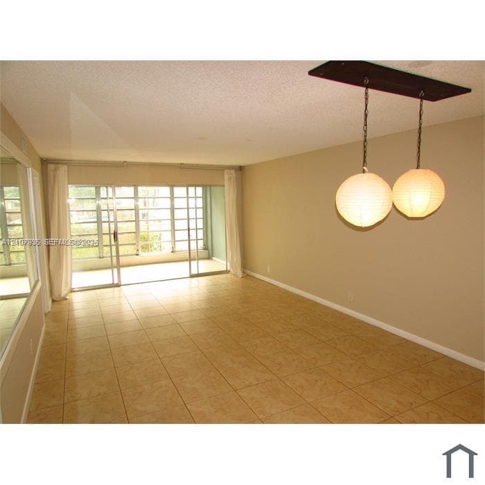 Ceramic tile flooring, sliding glass patio doors, wall-mounted mirror, and dual spherical globe pendant lighting
