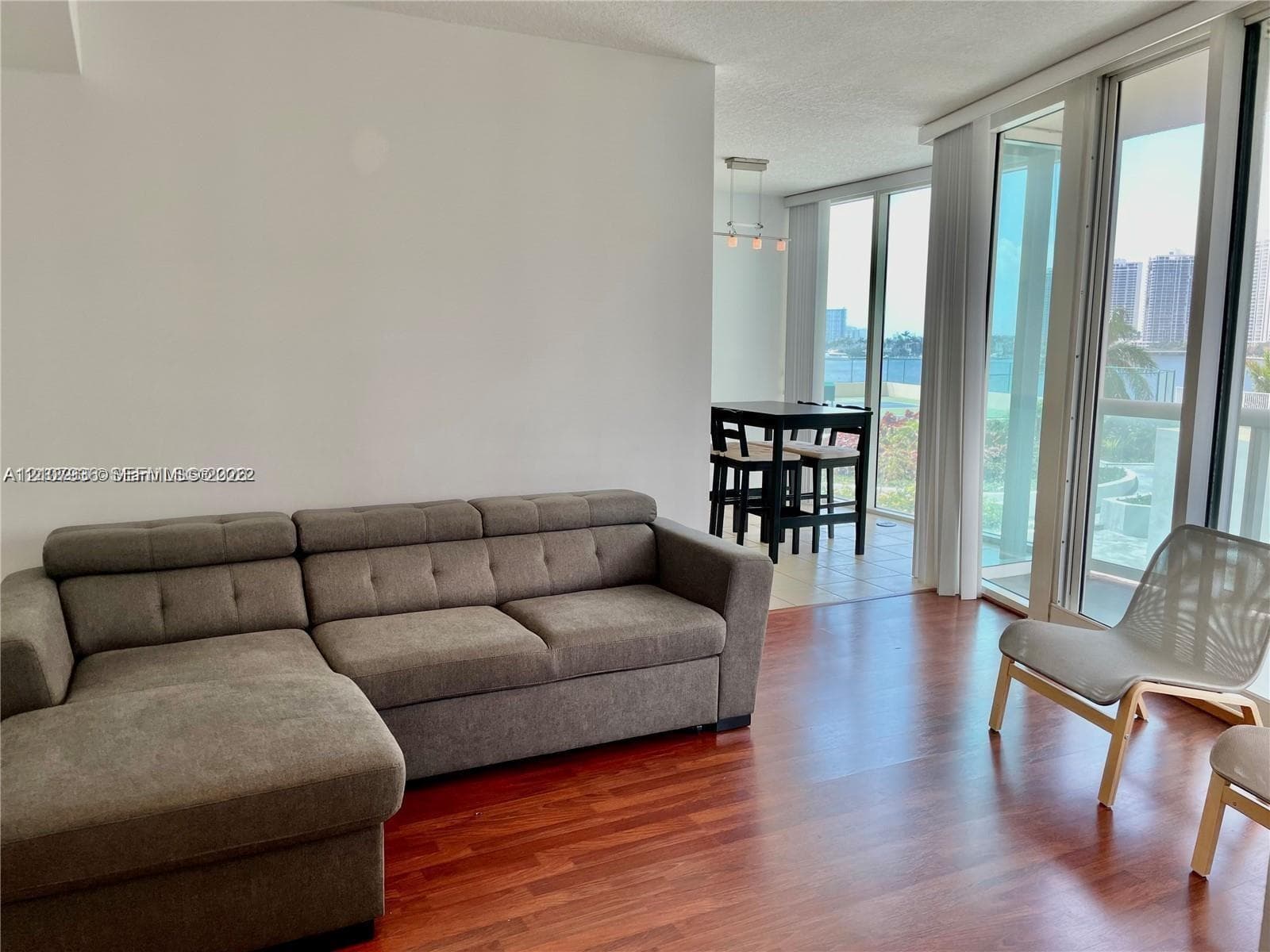 Floor-to-ceiling windows, wood-finish flooring, and recessed ceiling lighting