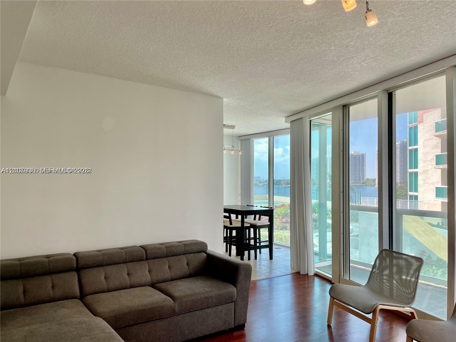 Floor-to-ceiling glass panel walls, wood-finish flooring, and recessed ceiling lighting