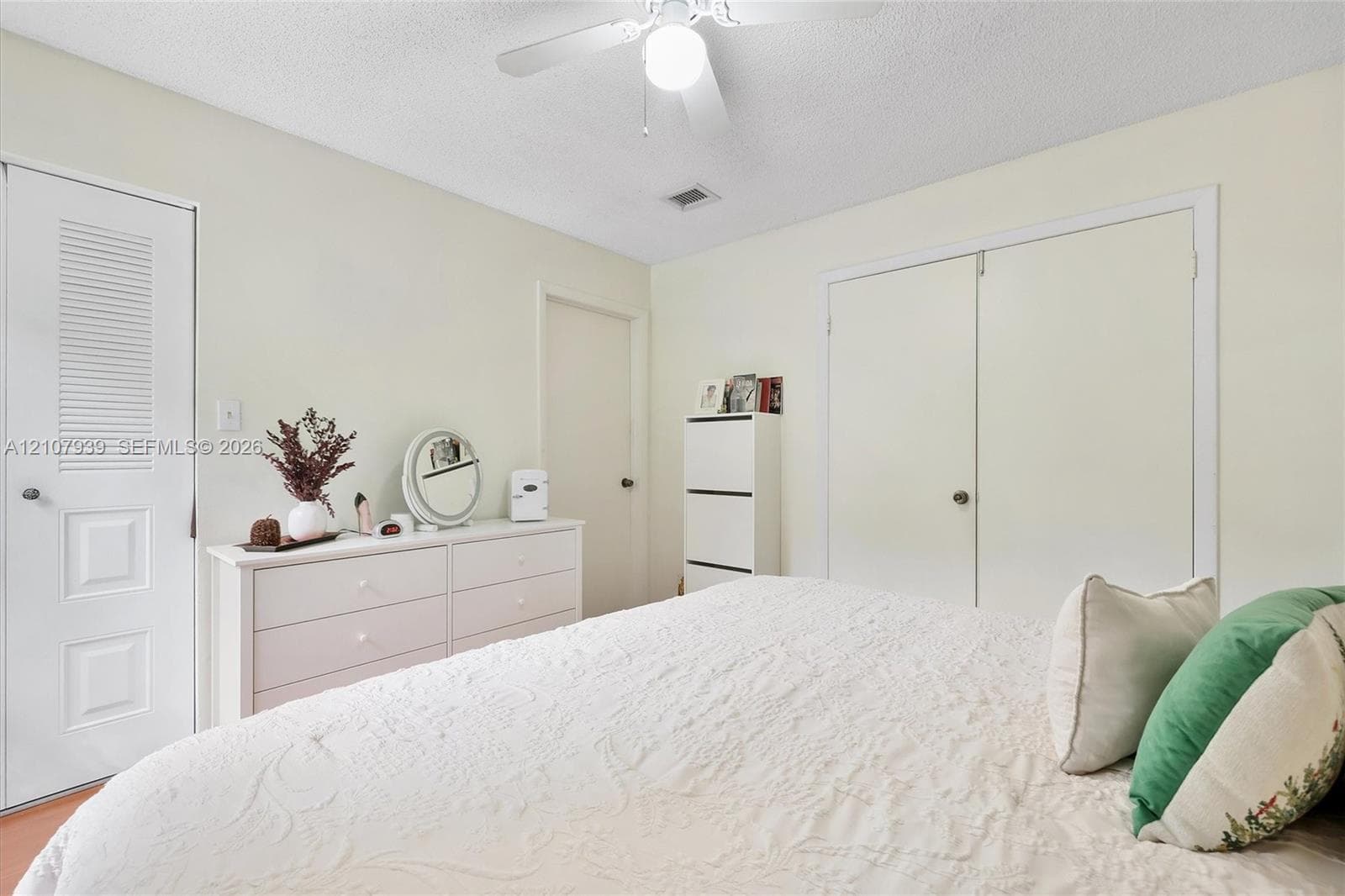 Interior space featuring dual-panel closet doors, louvered closet door, ceiling fan with integrated lighting, and neutral wall color