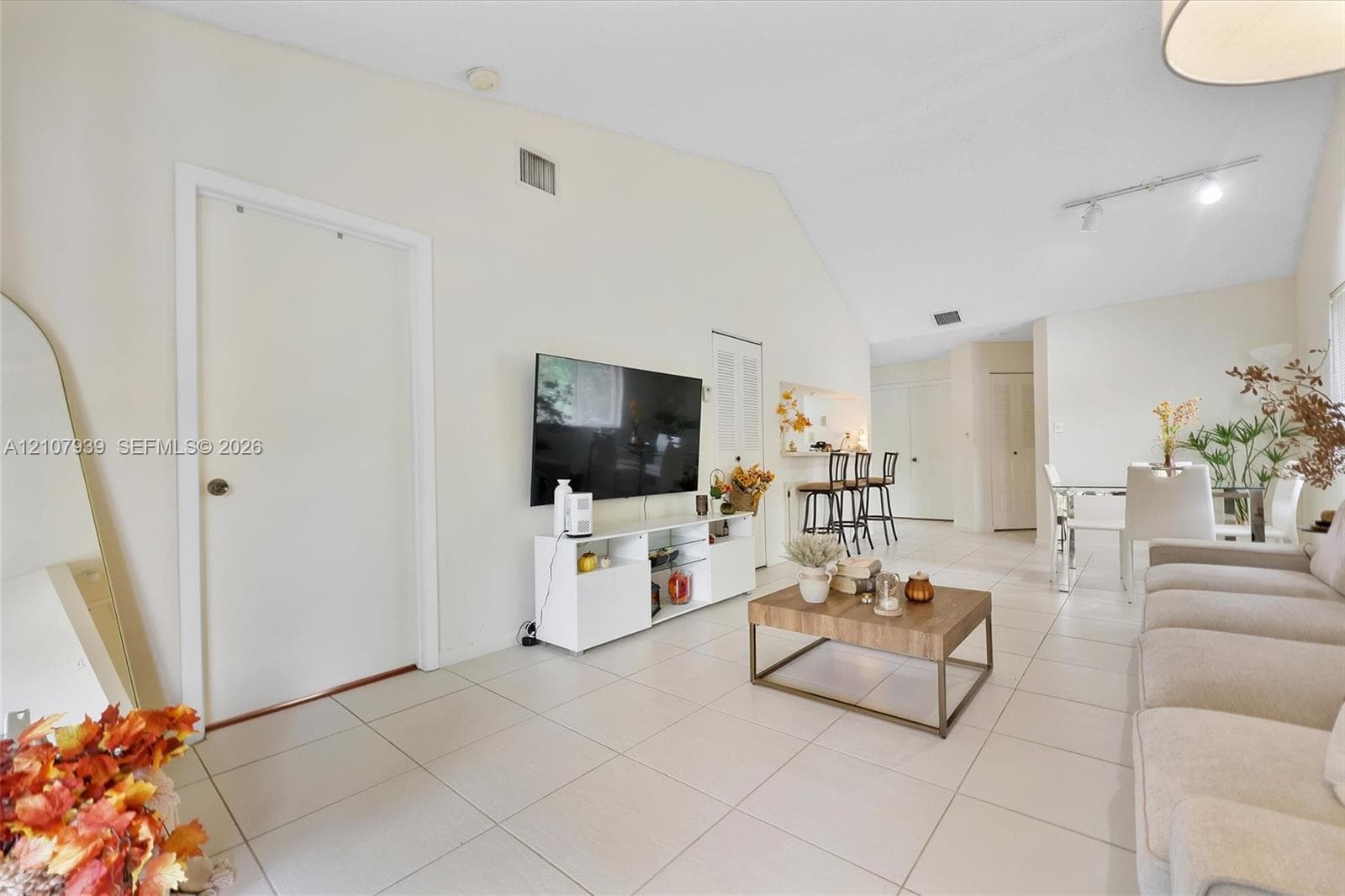 Vaulted ceilings, large-format tile flooring, and adjustable track lighting