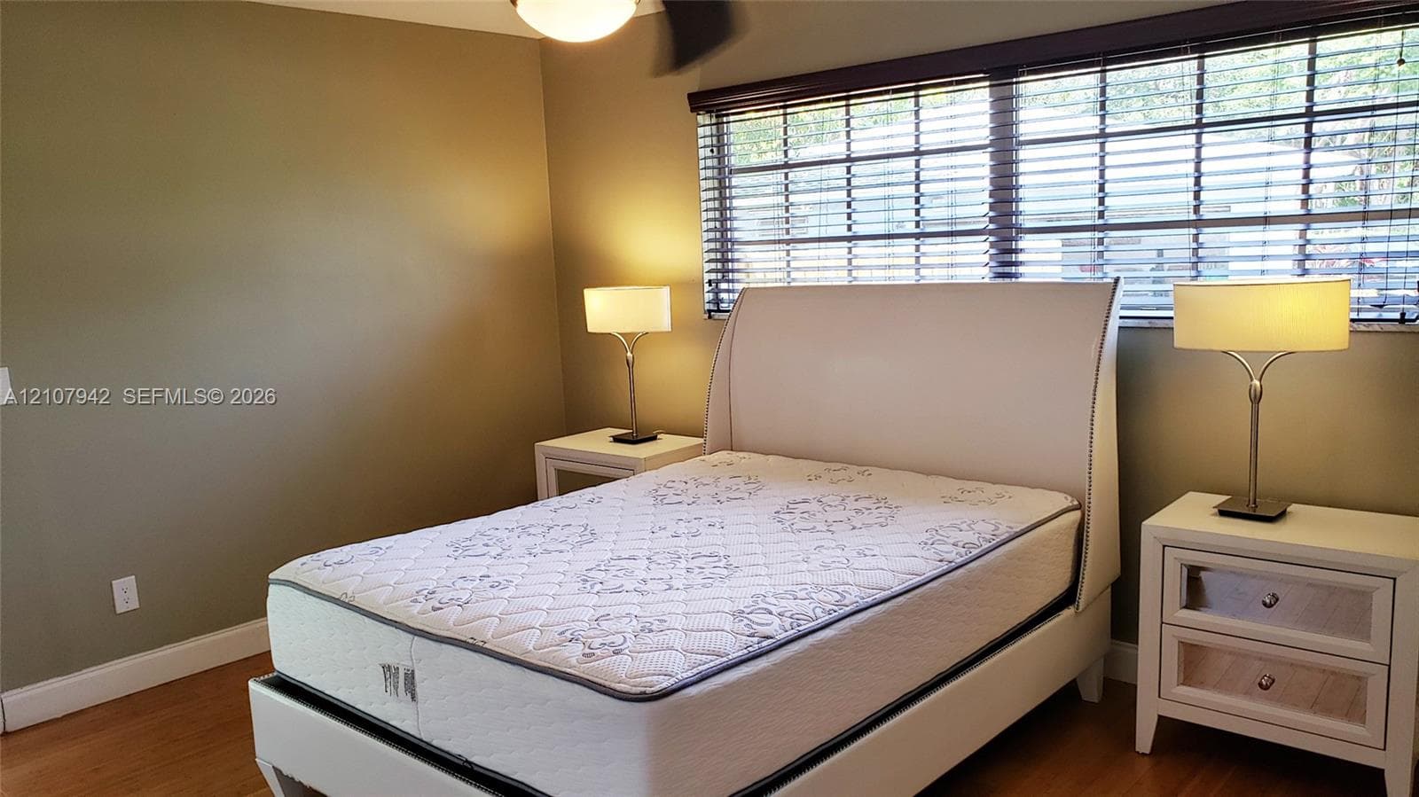 Neutral-toned walls, wood-finish flooring, and horizontal window blinds