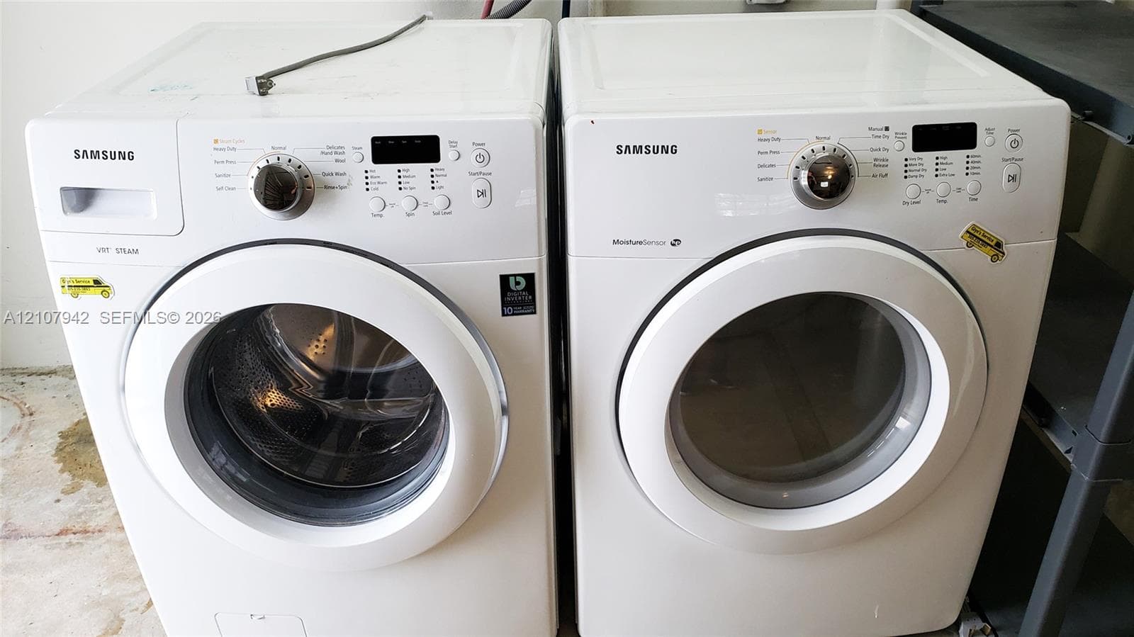 White Samsung front-load washer and dryer set featuring steam cycle technology and moisture sensor controls