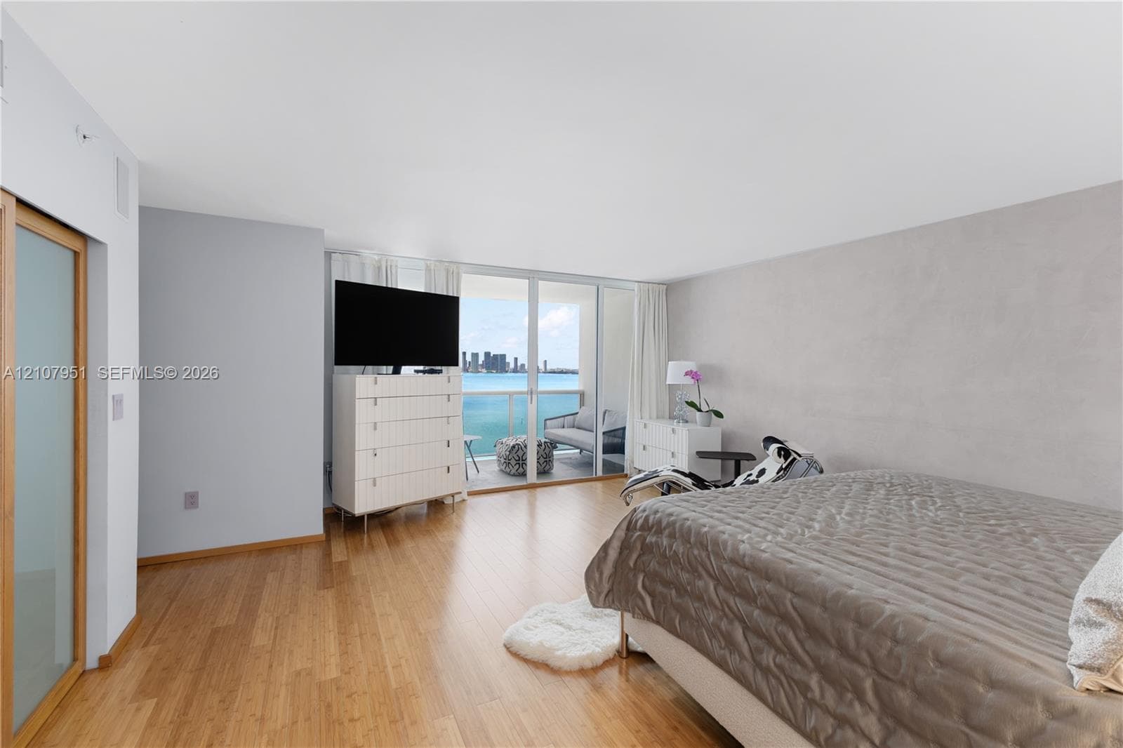 Wood-finish flooring, floor-to-ceiling glass sliding doors, and private balcony