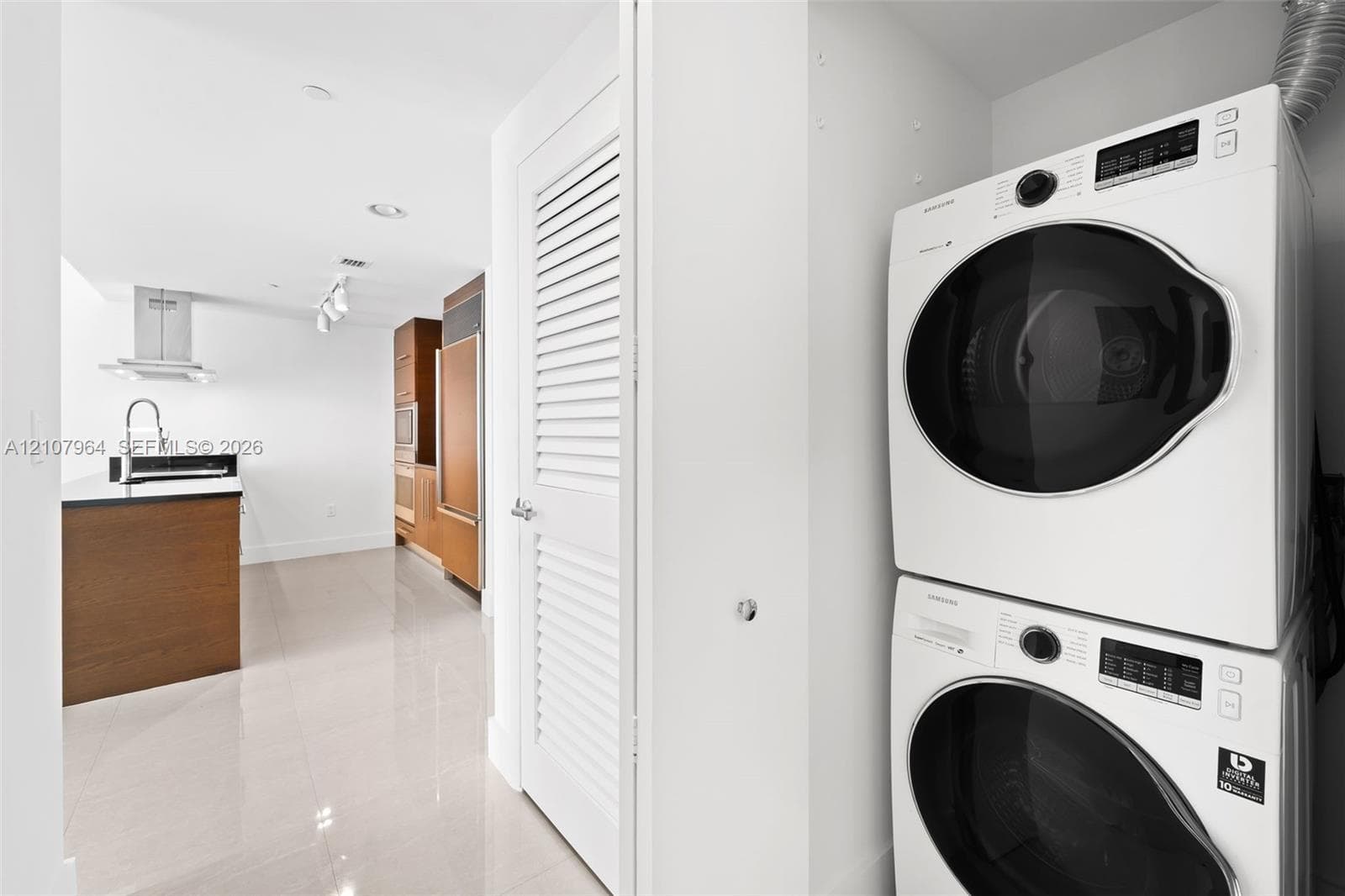 Stacked laundry unit featuring white front-load appliances