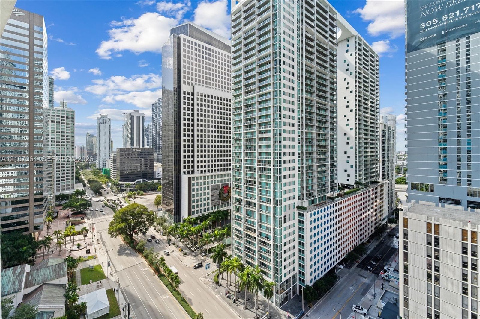 High-rise building featuring a glass facade, private balconies, and an urban cityscape setting
