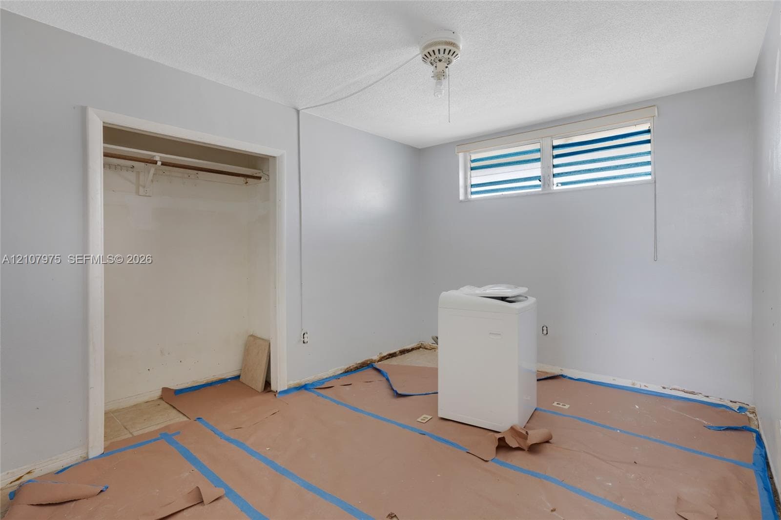 Bathroom featuring square white wall tiling, a built-in shower enclosure, a white porcelain toilet, and a recessed window