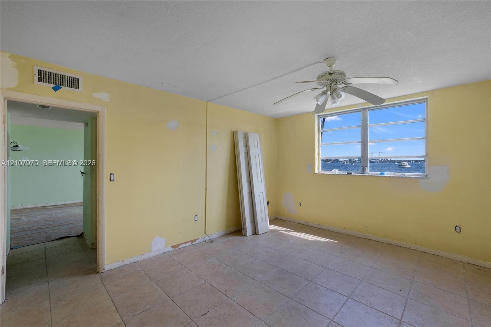 Multi-story building featuring screened balconies, landscaped grounds, and paved walkways