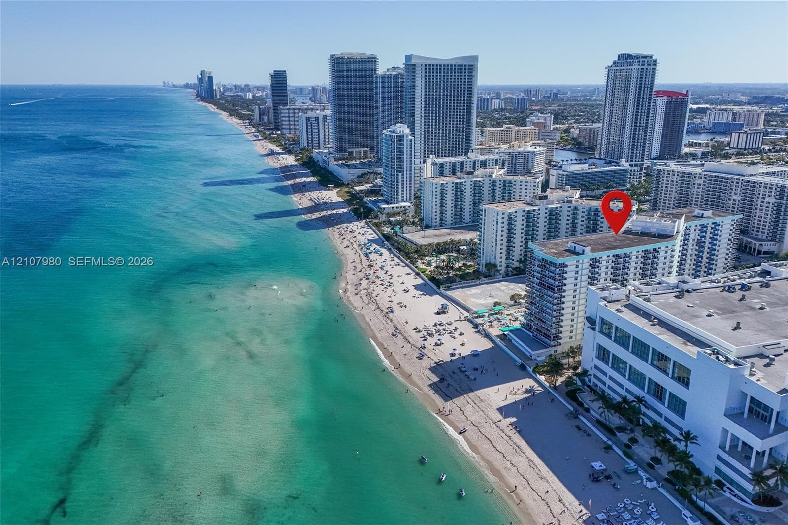 Aerial perspective featuring a beachfront high-rise building with direct ocean access and proximity to coastal landmarks