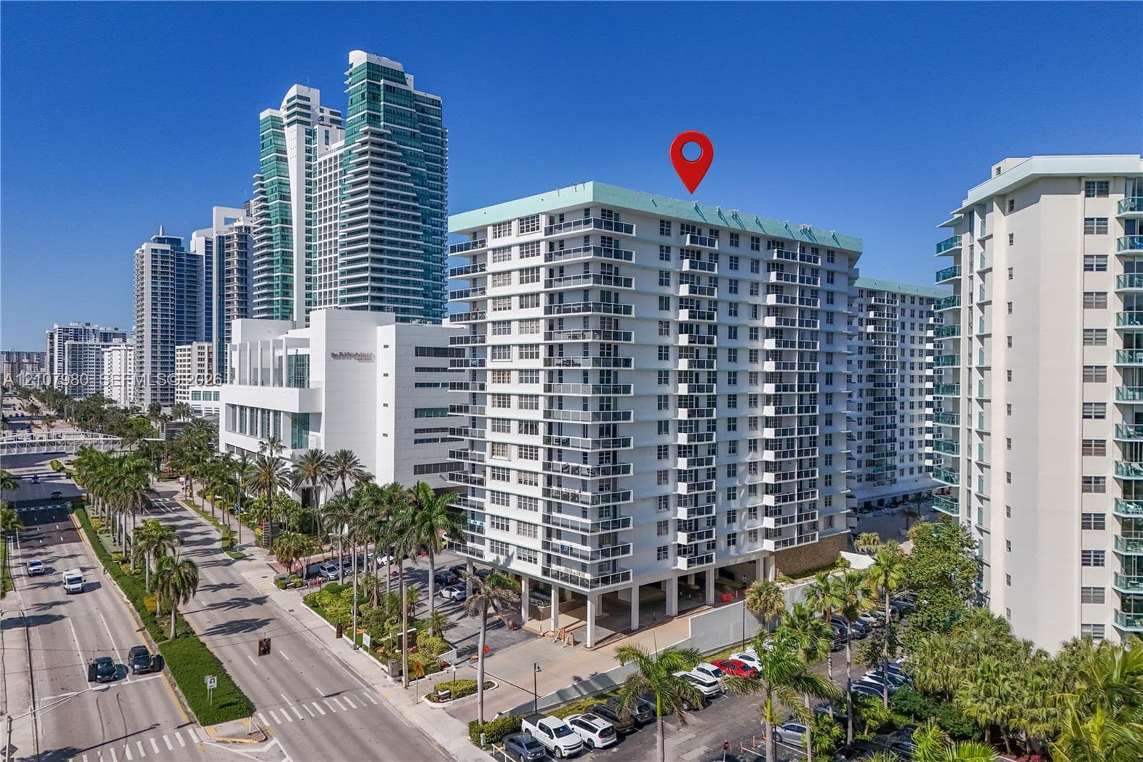 High-rise residential building featuring private balconies, floor-to-ceiling glass doors, and covered ground-level parking