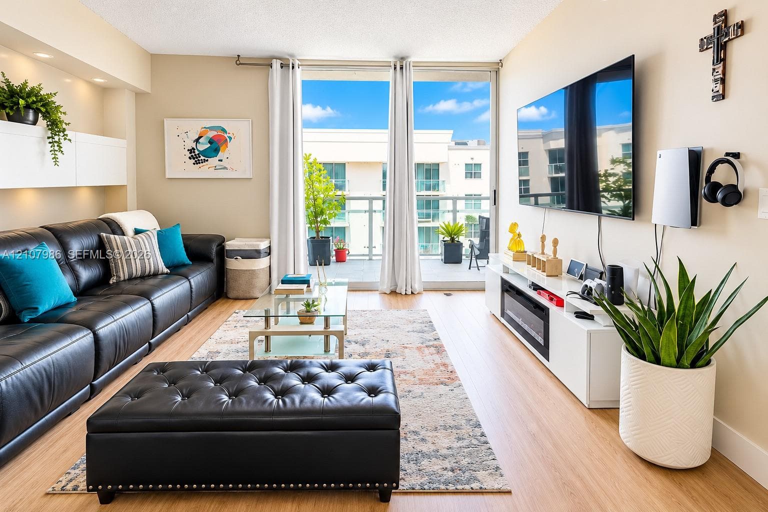Living space featuring wood-finish flooring, recessed lighting, built-in wall cabinetry, an electric fireplace, and a glass-paneled balcony