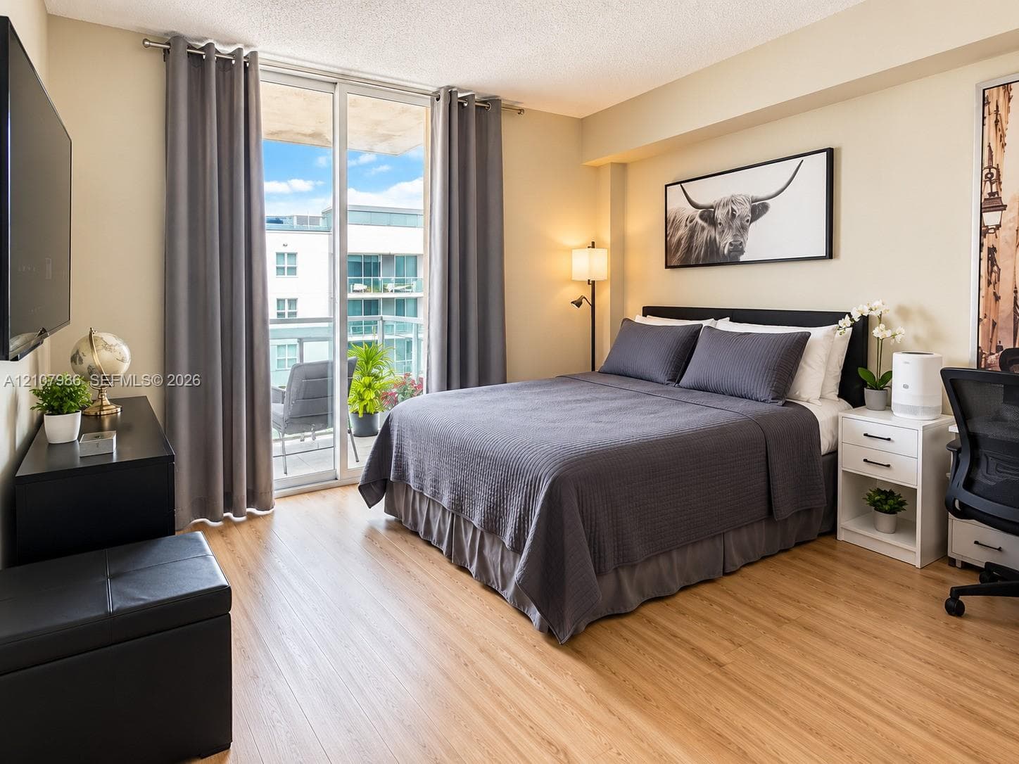 Wood-finish flooring and sliding glass door access to a balcony
