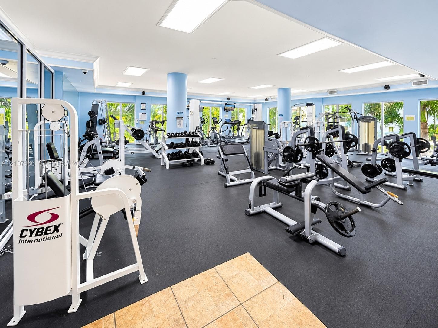 Fitness center featuring expansive floor-to-ceiling windows, recessed lighting, mirrored walls, and durable rubberized flooring