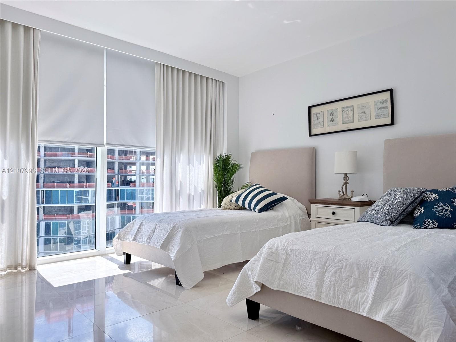 Floor-to-ceiling windows featuring automated roller shades, complemented by polished tile flooring and neutral wall finishes