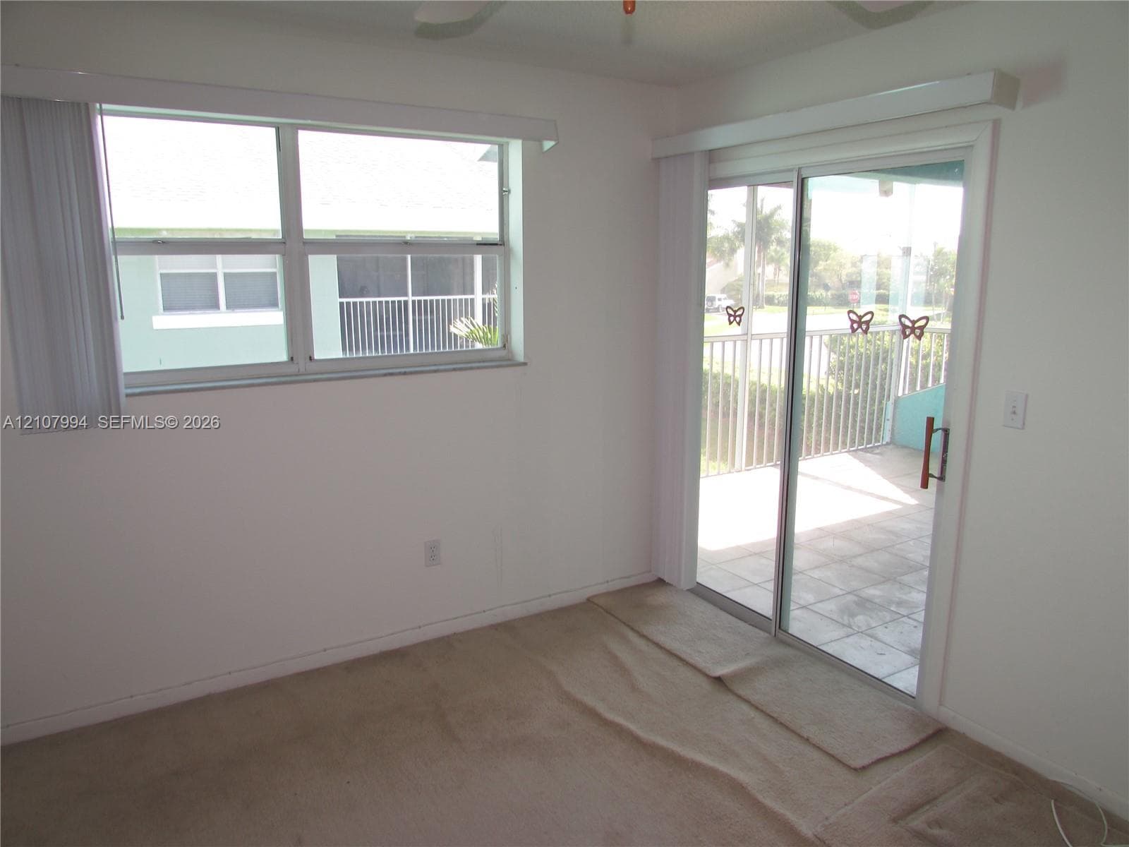 Interior space featuring a horizontal sliding window, full-length sliding glass door, and covered patio with tiled flooring