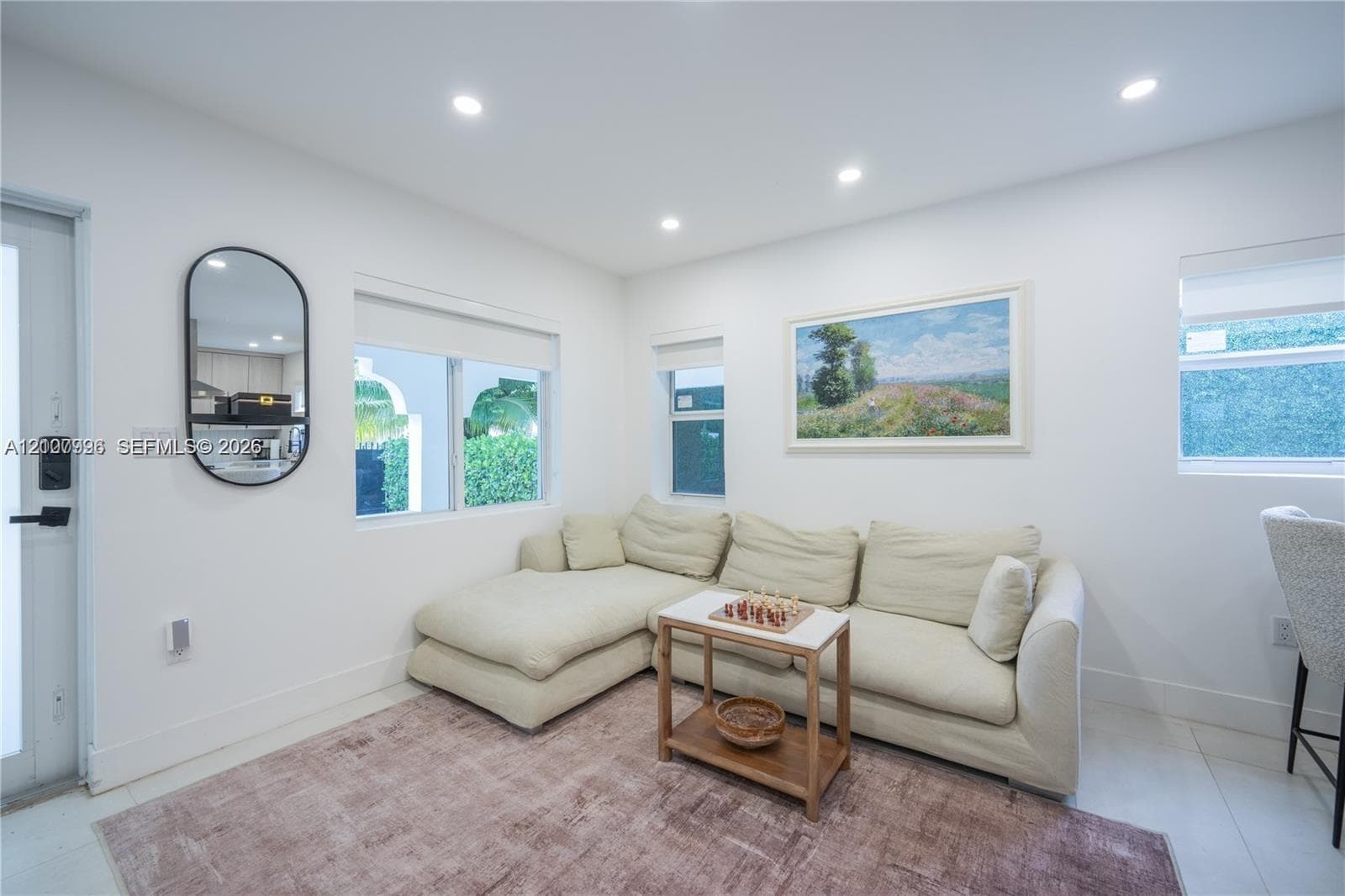 Bright interior space featuring recessed ceiling lighting, multiple windows, and neutral-toned smooth surface flooring