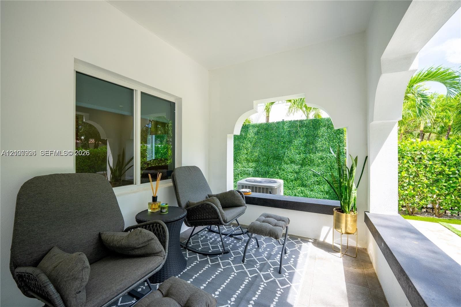 Covered porch featuring arched openings, tile flooring, and integrated concrete ledge seating