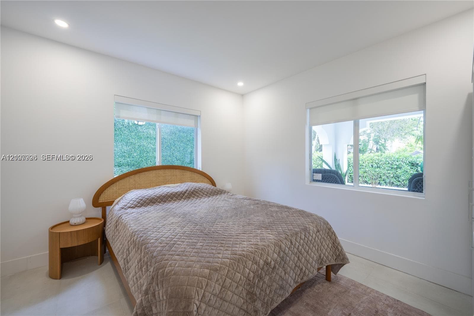 Neutral-toned interior featuring recessed lighting, smooth wall finishes, light-toned tile flooring, and oversized windows equipped with roller shades