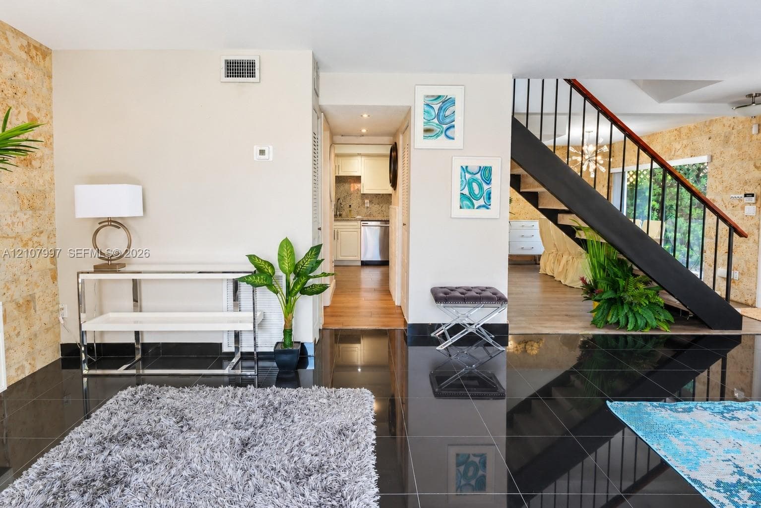 Polished black tile flooring, sliding glass doors and large windows