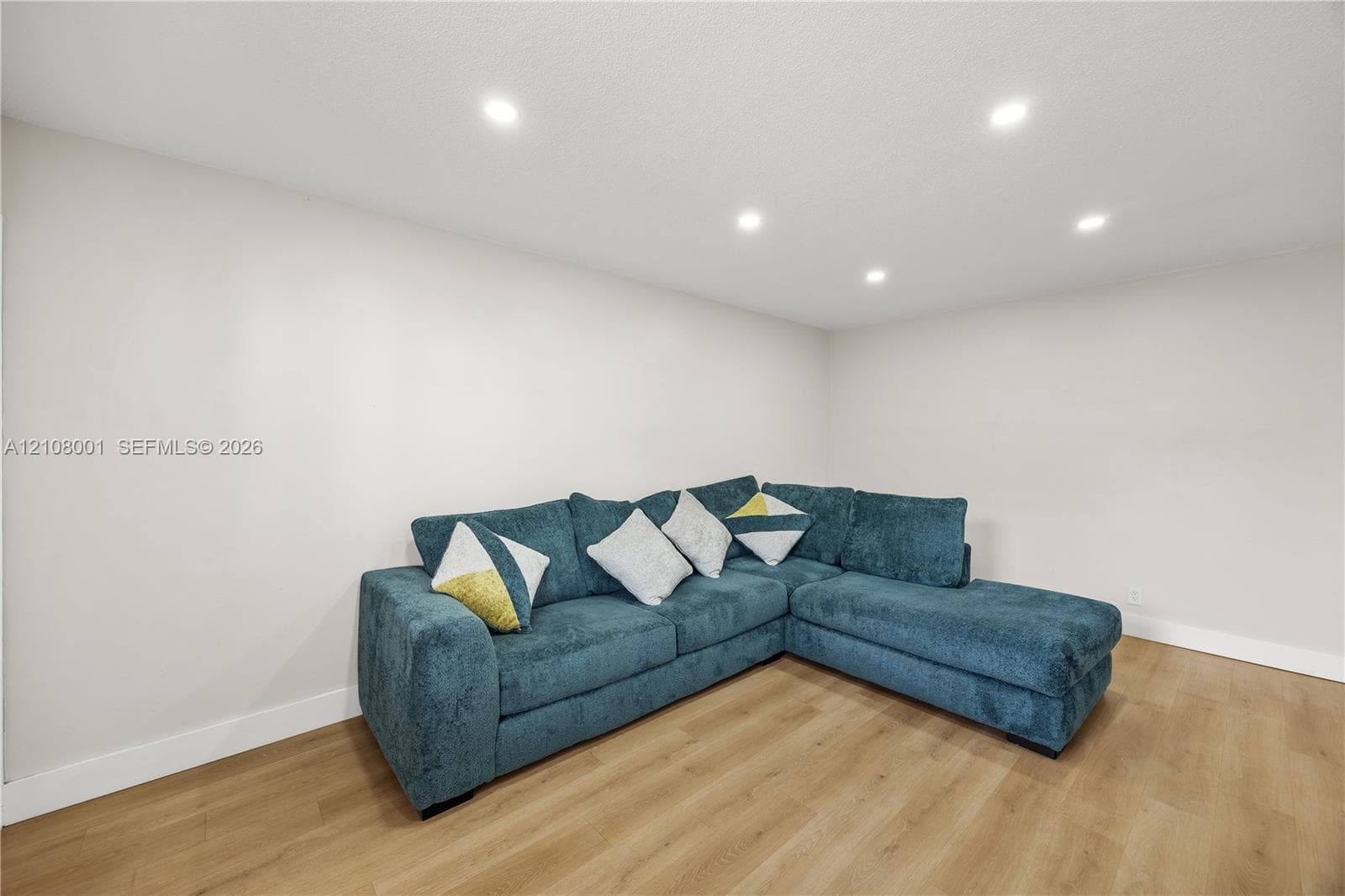 Neutral wall paint, wood-finish flooring, and recessed ceiling lighting