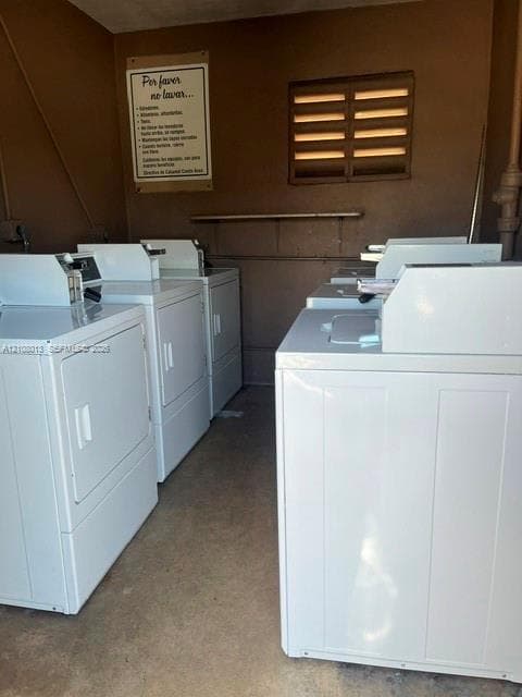 Laundry center equipped with multiple white top-load washers and dryers, louvered wall vent, and concrete flooring