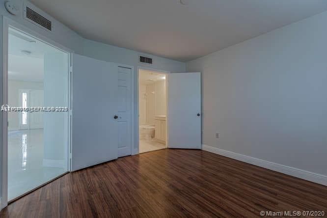 Interior space featuring wood-finish flooring, white paneled doors, and neutral wall tones