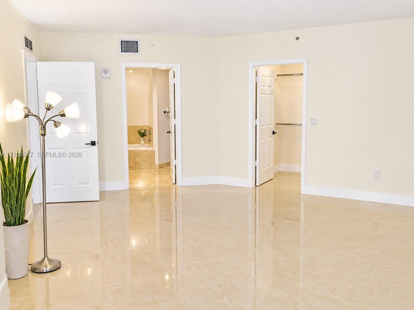 Polished tile flooring, six-panel interior doors with black hardware, and built-in closet shelving