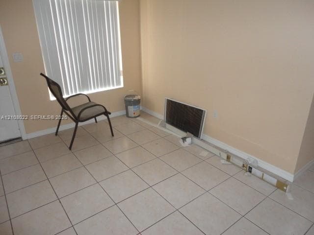 Neutral-toned ceramic tile flooring and white horizontal window blinds