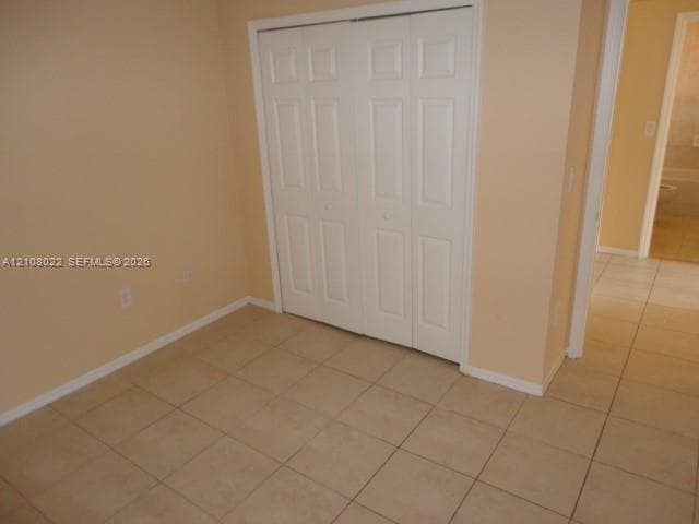 Room featuring tile flooring and a white paneled bi-fold closet