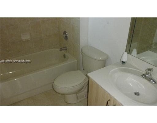 Full bathroom featuring a tub-shower combination with tile surround, an oval vanity sink with a metal faucet, and a light-finish wood cabinet