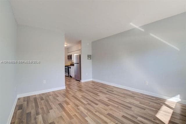 Open-concept interior featuring wood-finish flooring, neutral wall tones, and recessed lighting