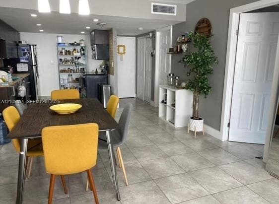 Open-concept interior featuring large-format ceramic tile flooring, recessed lighting, and multi-panel interior doors