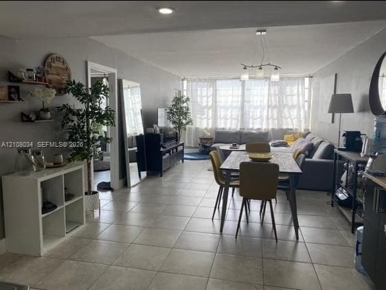 Open-concept interior featuring large-format tile flooring, recessed lighting, and a multi-light pendant fixture